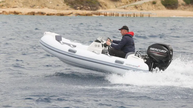 Slide: The Image of 2022 Northstar Axis 3.4 inflatable boat with Mercury engine on open water. - 2