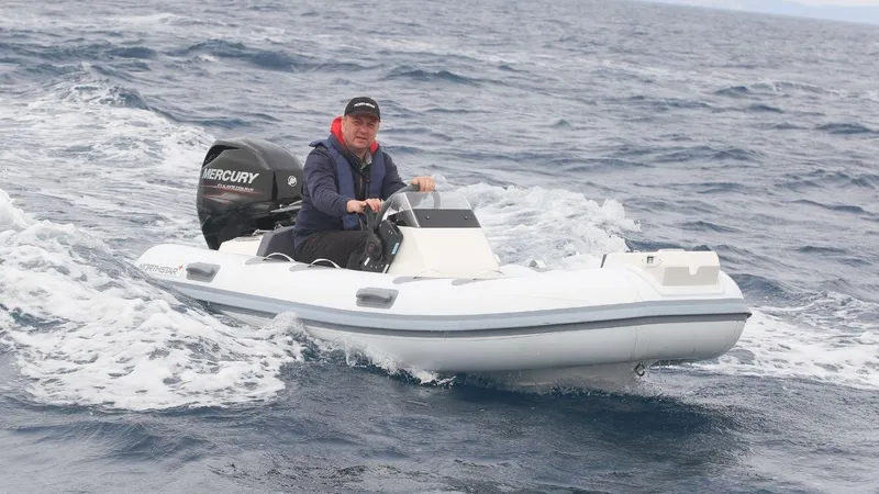 Slide: The Image of Man driving 2022 Northstar Axis 3.4 inflatable boat on open water. - 4