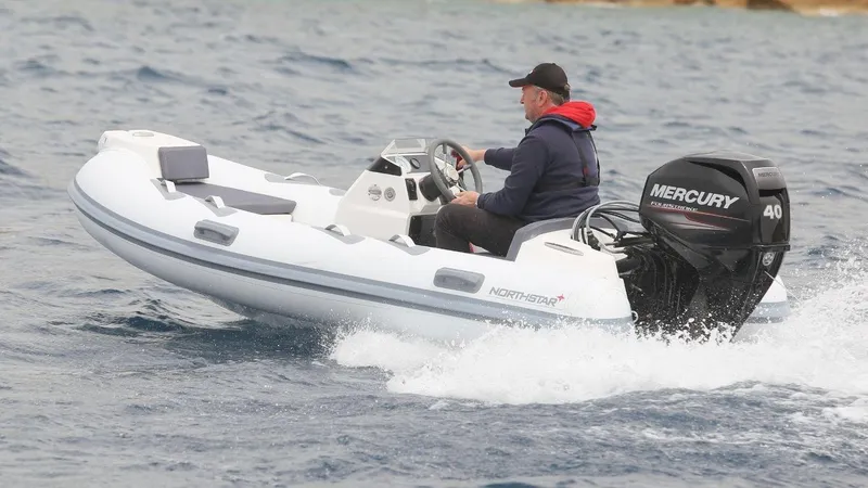 Slide: The Image of 2022 Northstar Axis 3.4 inflatable boat with Mercury engine on water. - 5