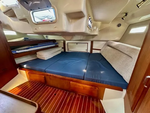 Slide: The Image of Interior cabin of 1993 Hunter Legend 40.5 sailboat with blue cushions and wood flooring. - 16