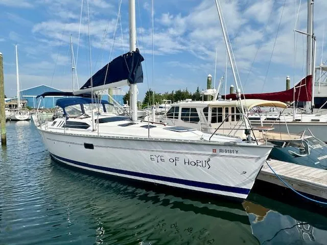 Slide: The Image of 1993 Hunter Legend 40.5 sailboat "Eye of Horus" docked in marina under blue sky. - 2
