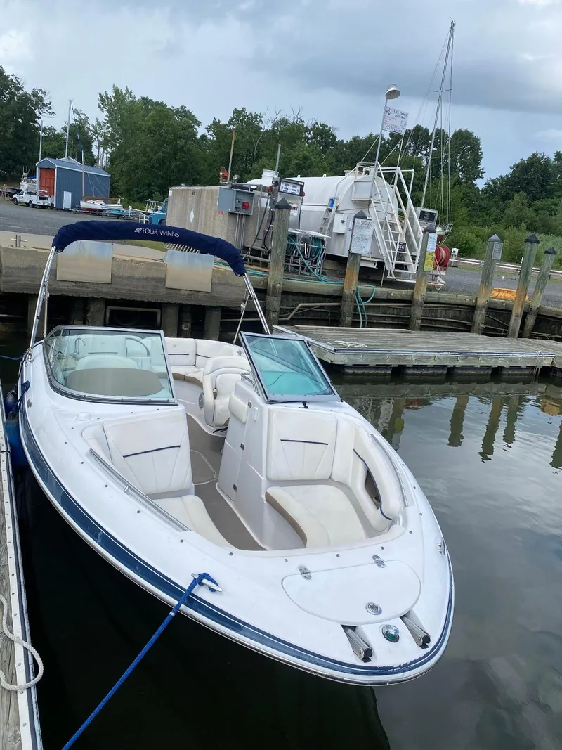 Slide: The Image of 2007 Four Winns 240 Horizon boat docked at a marina, featuring spacious seating and sleek design. - 1