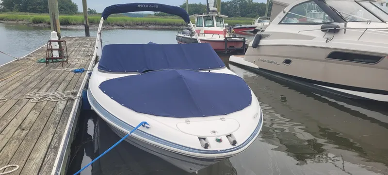 Slide: The Image of 2007 Four Winns 240 Horizon boat docked with blue covers, adjacent to other boats. - 10