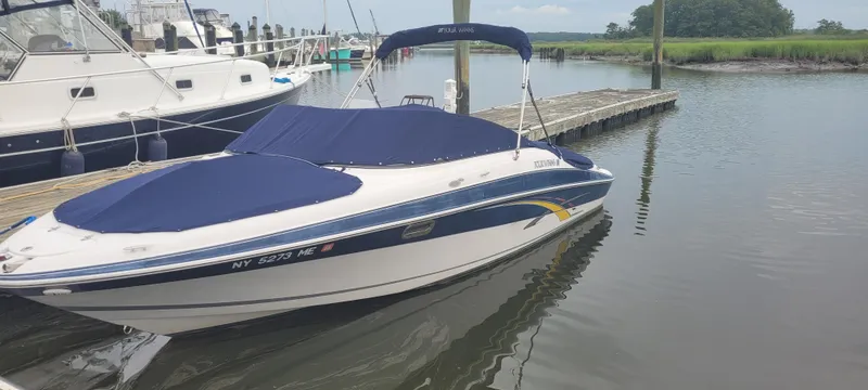 Slide: The Image of 2007 Four Winns 240 Horizon boat docked in a marina, covered with a blue tarp. - 19