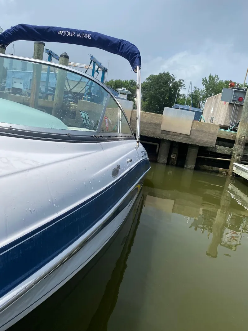 Slide: The Image of 2007 Four Winns 240 Horizon boat docked in a marina, featuring a blue and white exterior. - 7