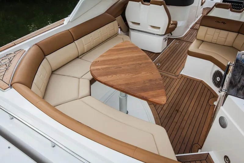 Slide: The Image of Manufacturer Provided Image: 2019 Sea Ray SLX 350 boat interior with tan leather seating and wooden table. - 13