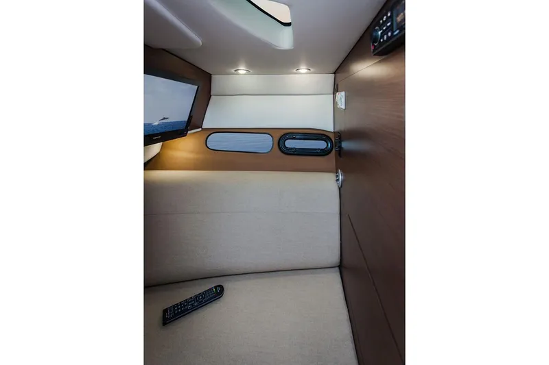 Slide: The Image of Manufacturer Provided Image: Interior cabin of 2019 Sea Ray SLX 350 with beige seating and remote control. - 18