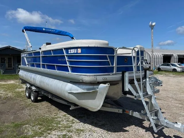 The Image of 2022 Sweetwater 2286 pontoon boat on trailer under clear blue sky. - 1