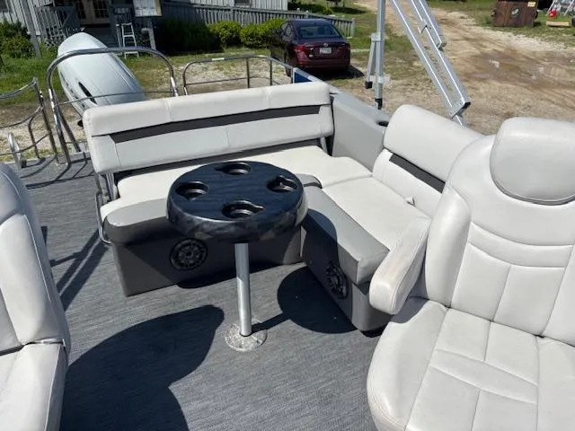 Slide: The Image of 2022 Sweetwater 2286 boat interior with gray seating and a round table. - 11