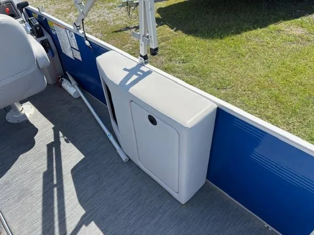Slide: The Image of 2022 Sweetwater 2286 boat interior with storage compartment and blue paneling. - 19