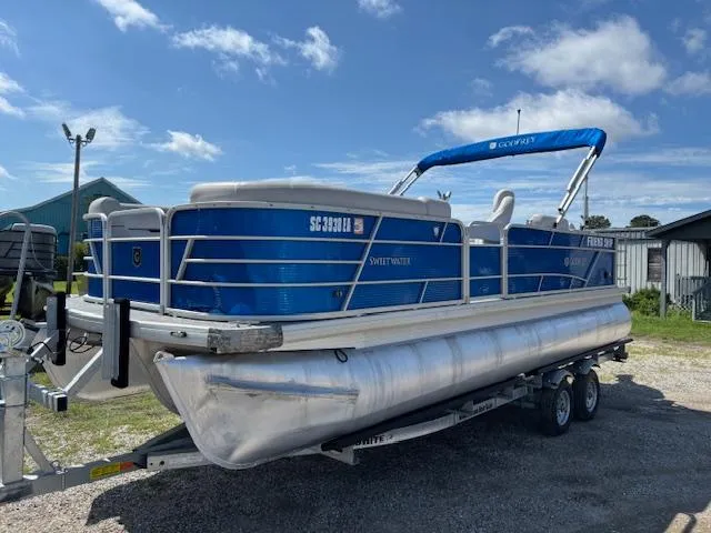 Slide: The Image of 2022 Sweetwater 2286 pontoon boat on trailer under blue sky. - 3