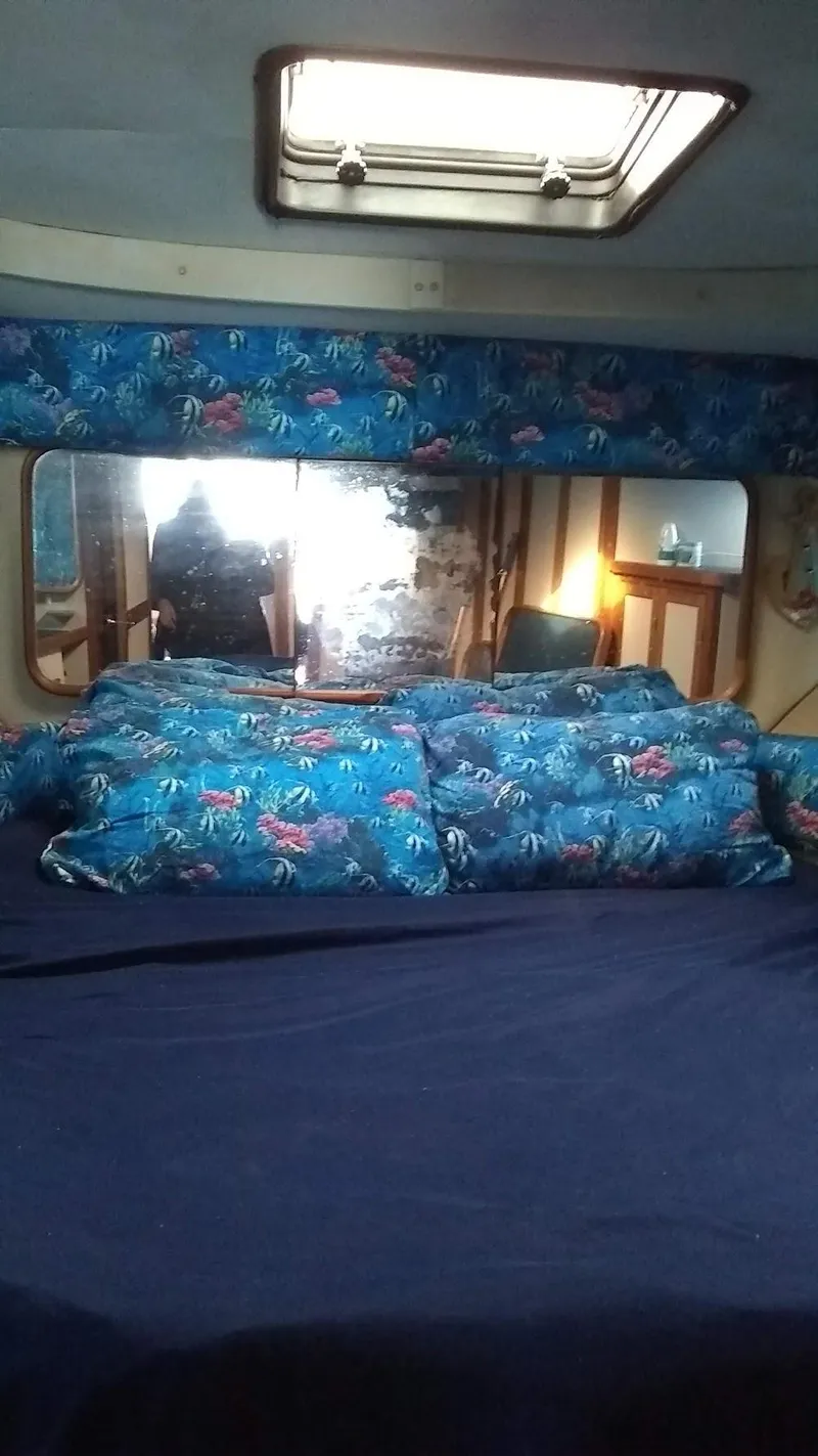 Slide: The Image of Interior of 1986 Carver 36 Mariner with floral bedding and skylight. - 10