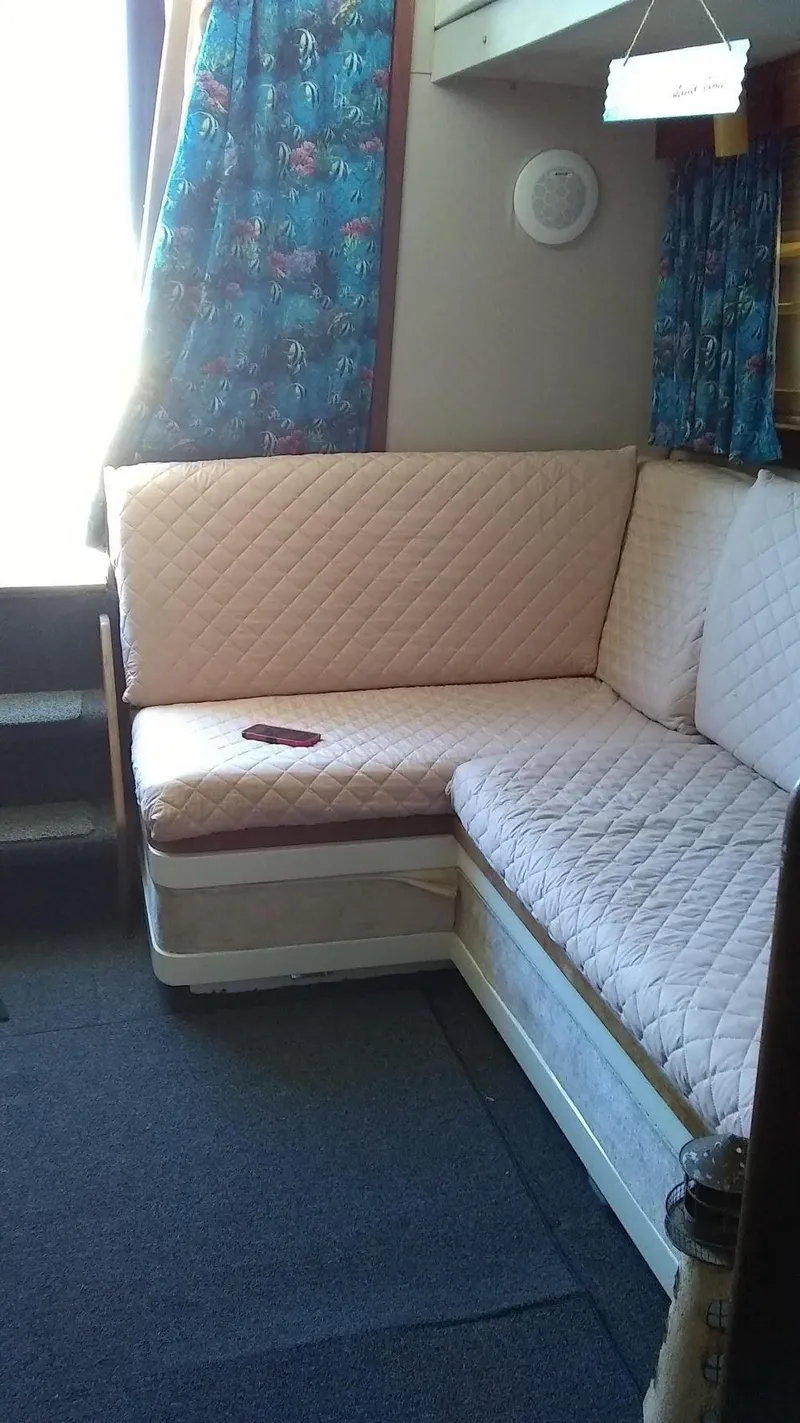 Slide: The Image of Interior of 1986 Carver 36 Mariner with quilted seating and colorful curtains. - 6
