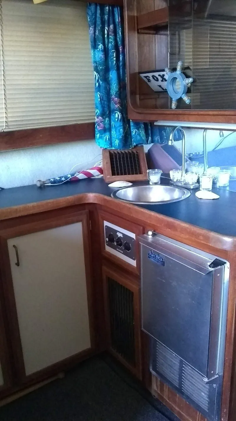 Slide: The Image of 1986 Carver 36 Mariner kitchen with sink, wooden cabinets, and nautical decor. - 7