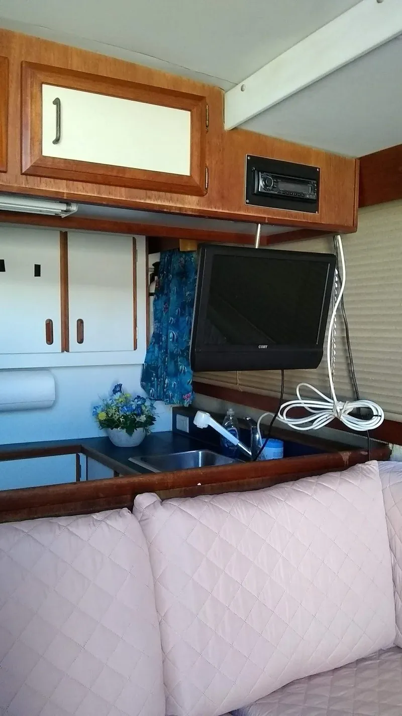 Slide: The Image of Interior of 1986 Carver 36 Mariner with TV, cabinets, and floral decor. - 9
