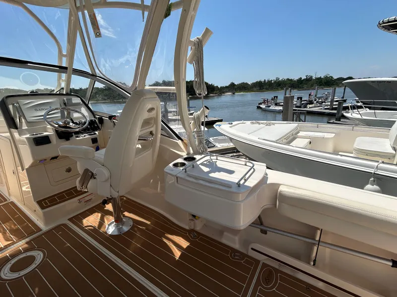Slide: The Image of 2018 Grady-White Freedom 235 boat interior with helm, seating, and water view. - 10