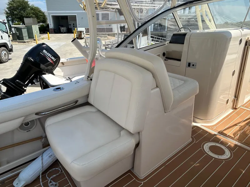 Slide: The Image of 2018 Grady-White Freedom 235 boat interior with seating and Suzuki outboard motor. - 12