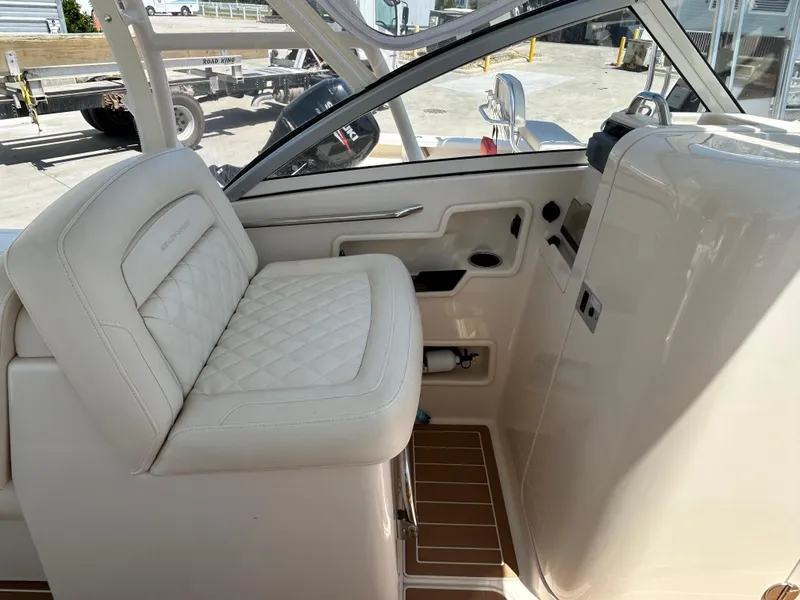 Slide: The Image of 2018 Grady-White Freedom 235 boat interior with white seating and dashboard. - 14