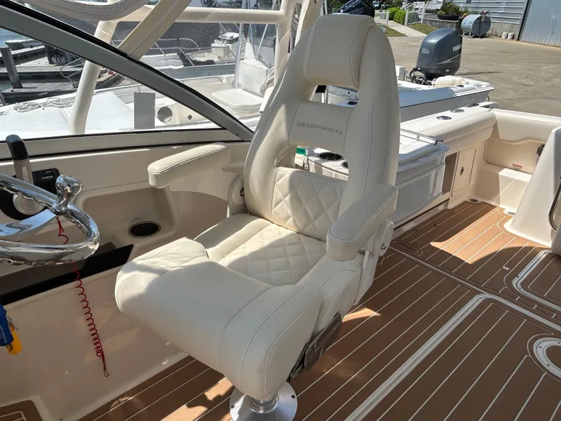 Slide: The Image of Captain's chair on 2018 Grady-White Freedom 235 boat, featuring luxurious white upholstery. - 16