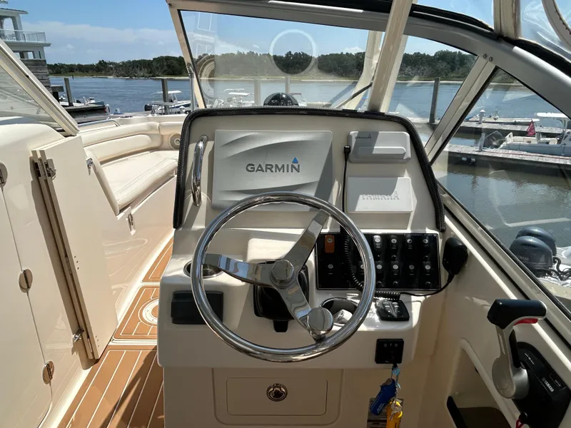Slide: The Image of 2018 Grady-White Freedom 235 boat helm with Garmin navigation, docked by the water. - 17