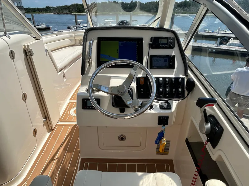 Slide: The Image of 2018 Grady-White Freedom 235 boat helm with steering wheel and navigation controls. - 18