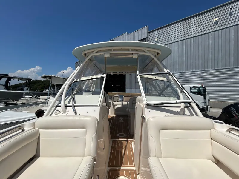 Slide: The Image of 2018 Grady-White Freedom 235 boat with spacious seating and sleek design, docked outdoors. - 32