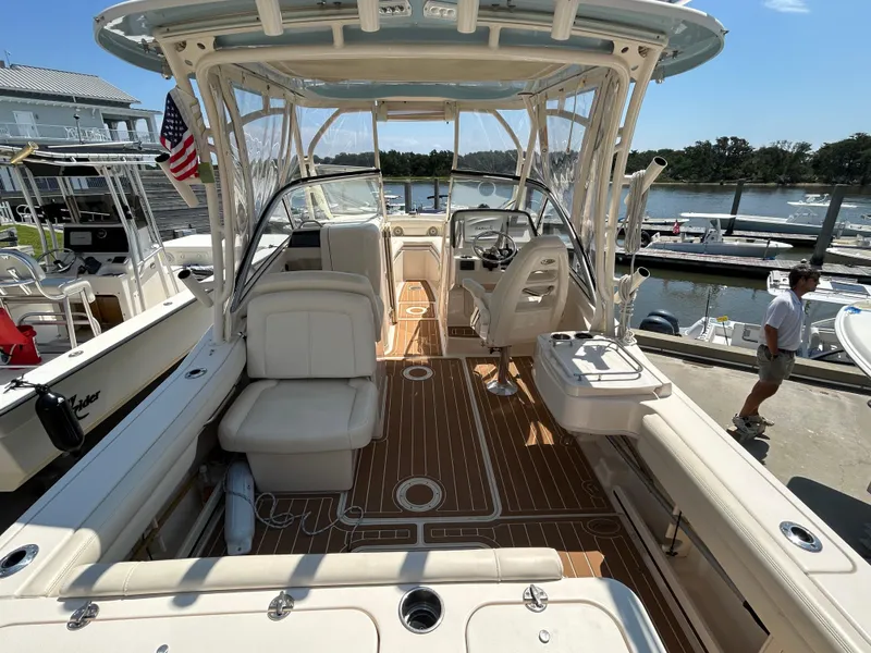 Slide: The Image of 2018 Grady-White Freedom 235 boat interior with seating and helm, docked by the water. - 5
