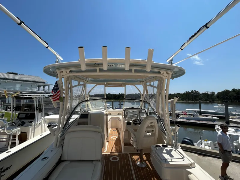 Slide: The Image of 2018 Grady-White Freedom 235 boat docked at marina under clear blue sky. - 6