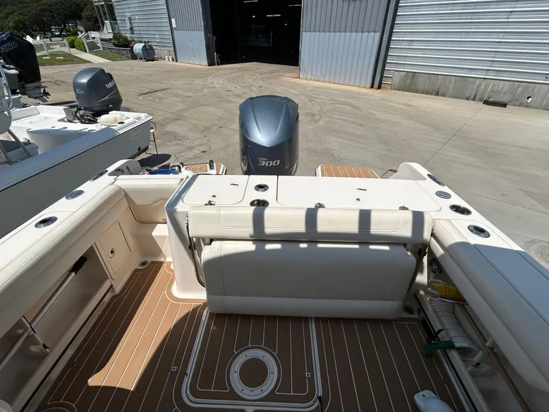 Slide: The Image of 2018 Grady-White Freedom 235 boat interior with Yamaha 300 engine, docked near a warehouse. - 7