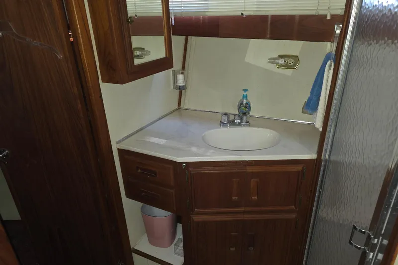 Slide: The Image of Bathroom interior of 1988 Marinette 37 Motor Yacht with wooden cabinets and sink. - 39