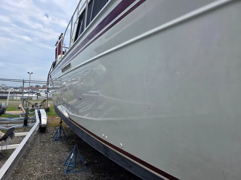 Slide: The Image of 1988 Marinette 37 Motor Yacht on stands, side view, marina background. - 4