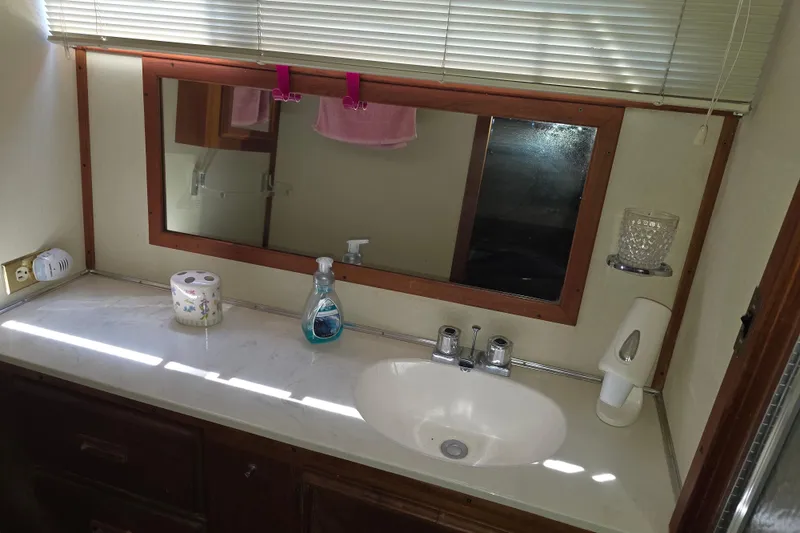 Slide: The Image of Bathroom sink area in 1988 Marinette 37 Motor Yacht with mirror and toiletries. - 53
