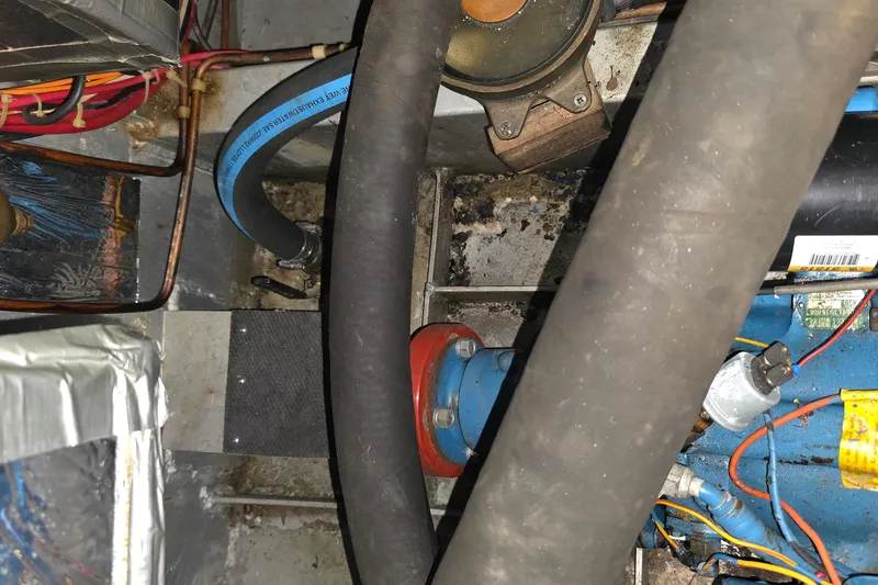 Slide: The Image of Engine compartment of a 1988 Marinette 37 Motor Yacht, showing hoses and wiring. - 58