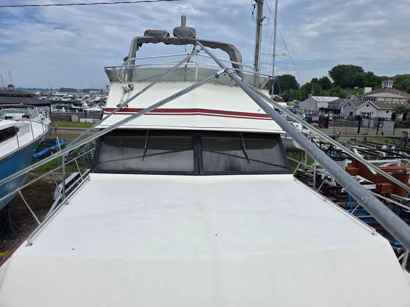 Slide: The Image of 1988 Marinette 37 Motor Yacht docked at marina, overcast sky, and surrounding boats. - 8