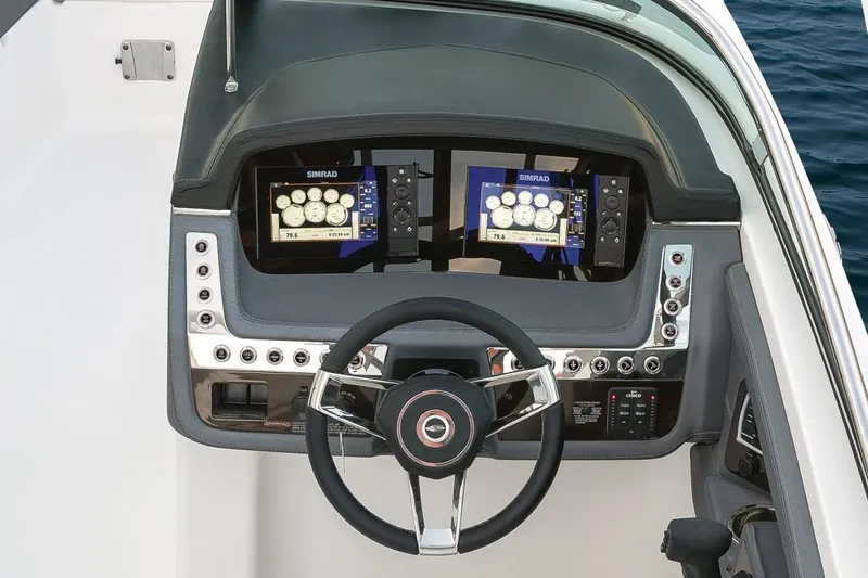 Slide: The Image of Manufacturer Provided Image: 2018 Chaparral 267 SSX boat dashboard with dual Simrad displays and steering wheel. - 21