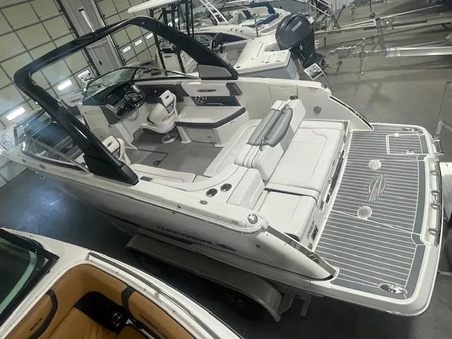 Slide: The Image of 2018 Chaparral 267 SSX boat with spacious seating and sleek design in a showroom. - 6