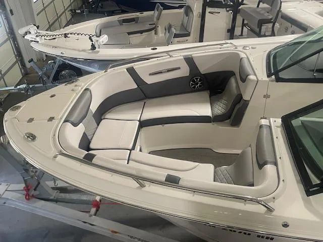 Slide: The Image of 2018 Chaparral 267 SSX boat interior with cushioned seating in a showroom. - 8