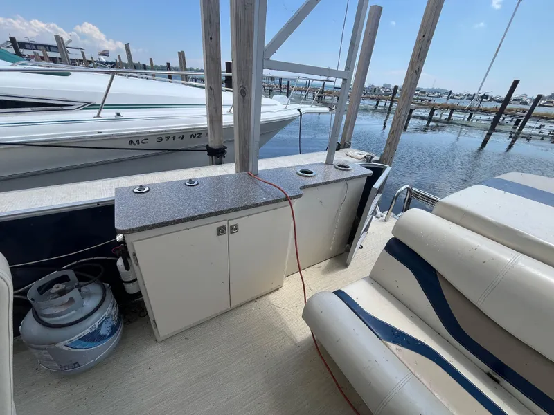 Slide: The Image of Boat interior with seating, storage cabinets, and propane tank on a 2016 King Mariner Custom. - 10