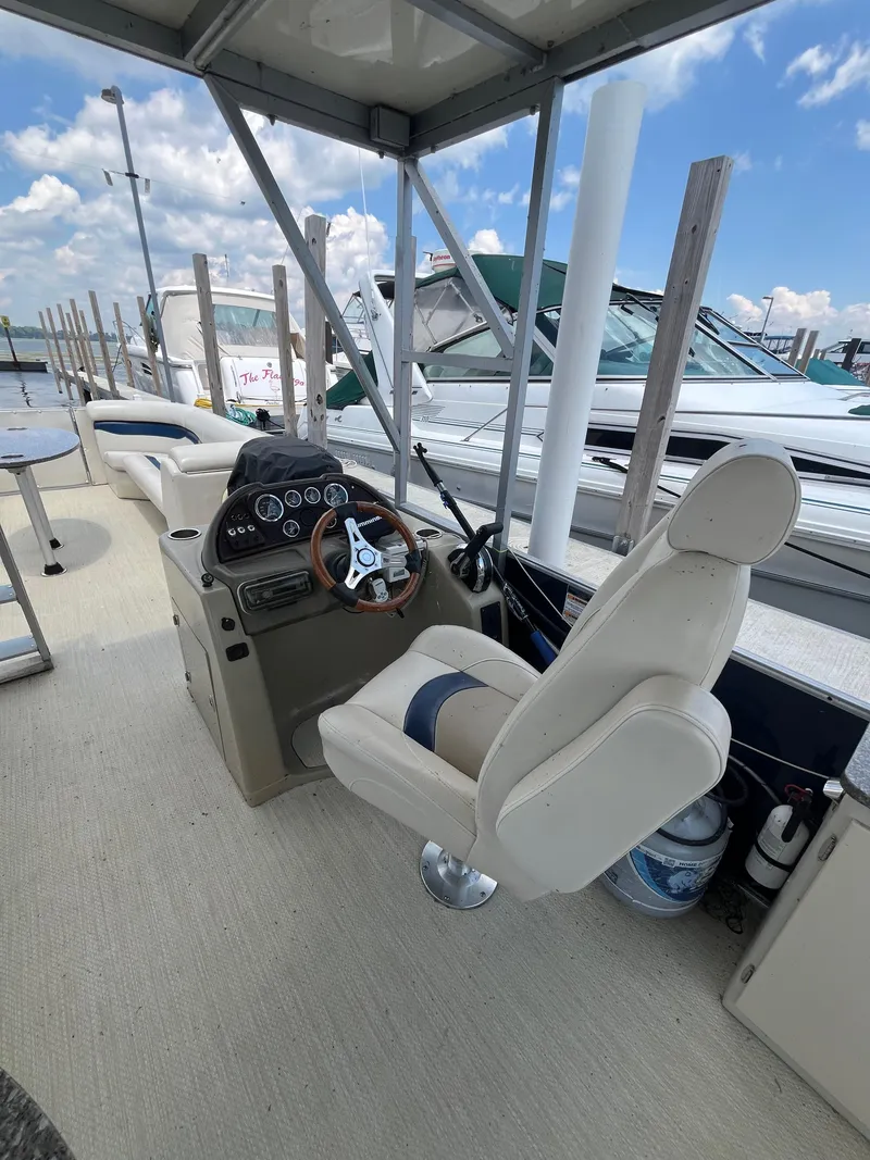Slide: The Image of 2016 Custom King Mariner boat interior with steering wheel and seating at a marina. - 11
