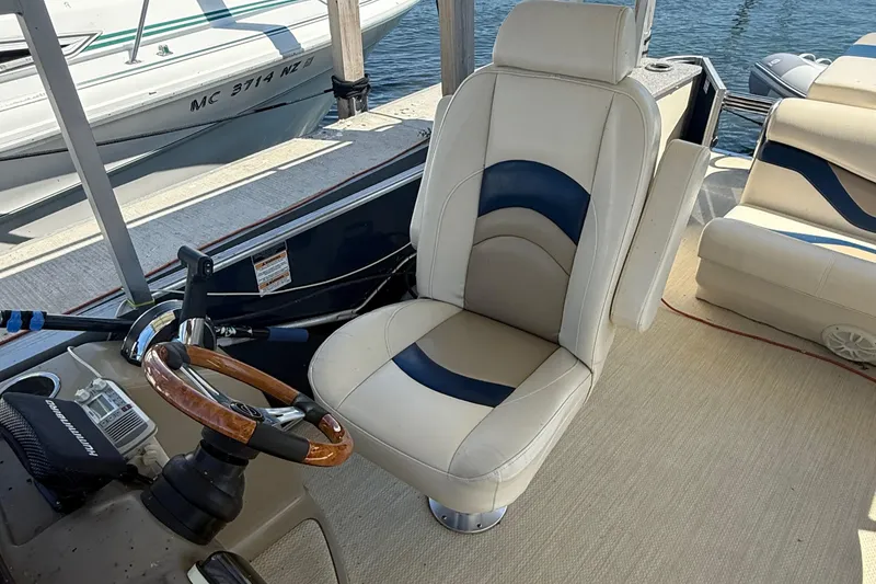 Slide: The Image of Captain's chair on 2016 King Mariner Custom boat, featuring a wooden steering wheel and nautical controls. - 16