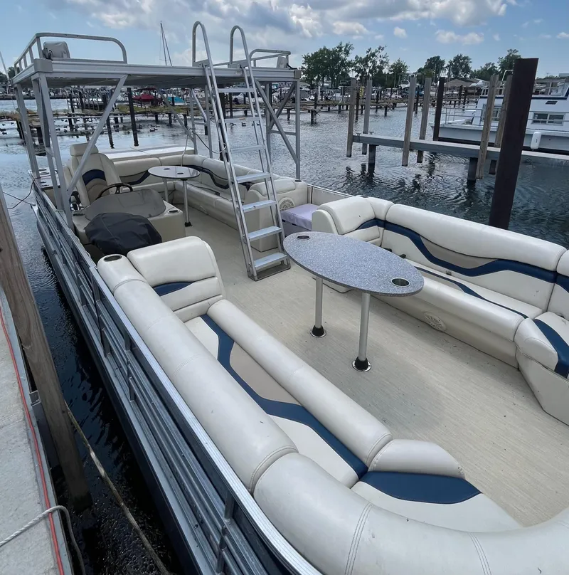 Slide: The Image of Pontoon boat with spacious seating, table, and ladder, docked at marina. Custom King Mariner 2016. - 4