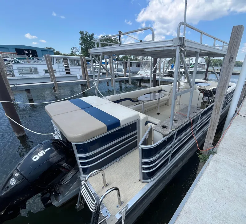 Slide: The Image of 2016 Custom King Mariner pontoon boat docked, featuring spacious seating and a powerful outboard motor. - 6