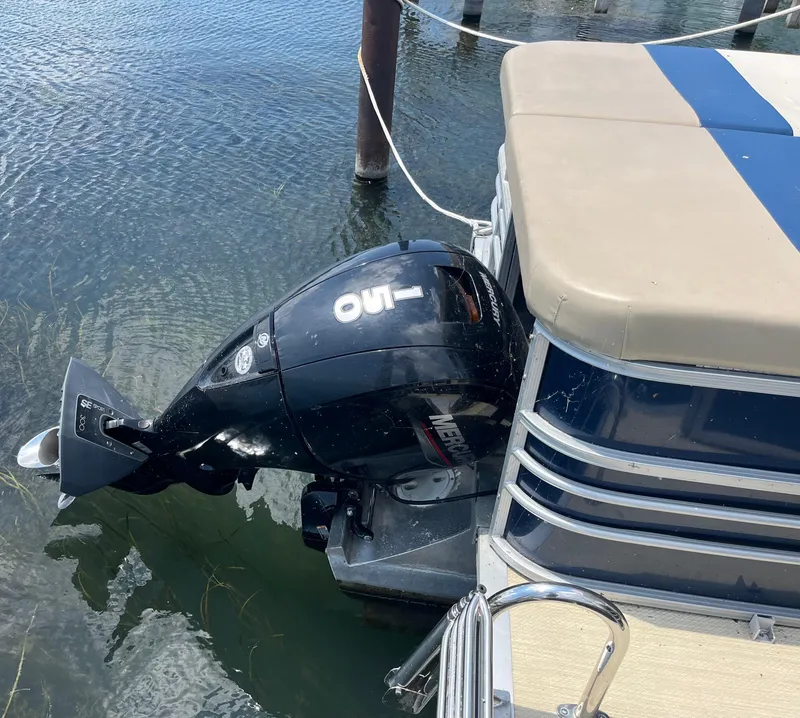 Slide: The Image of Outboard motor on a 2016 Custom King Mariner boat docked in clear water. - 8
