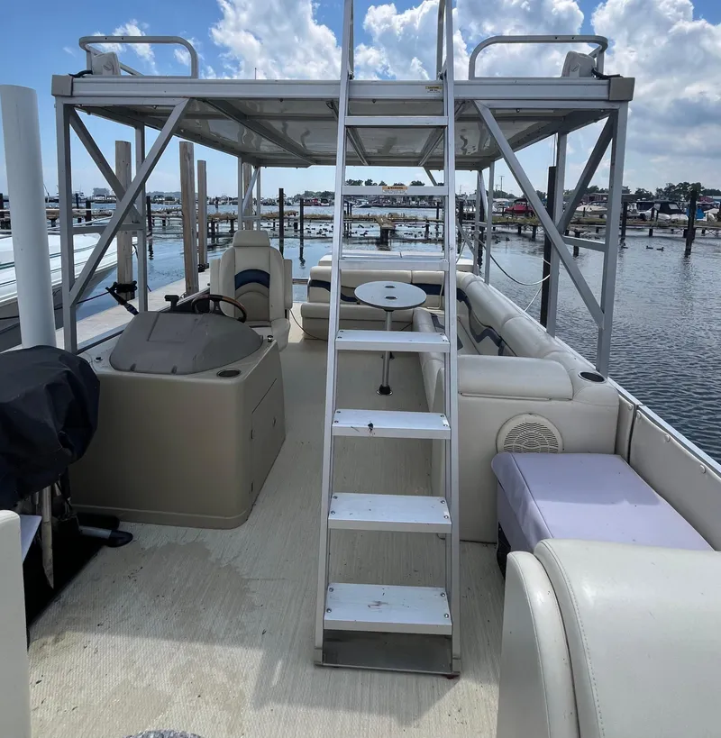 Slide: The Image of 2016 Custom King Mariner boat interior with seating, table, and ladder under a cloudy sky. - 9