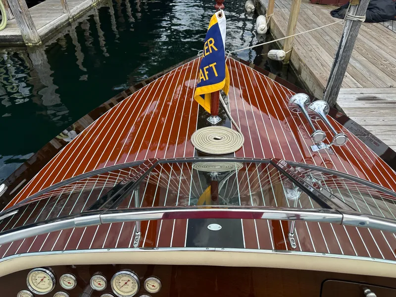 Slide: The Image of 1999 Hacker-Craft Custom Sport boat with polished wood deck and classic gauges at dock. - 11