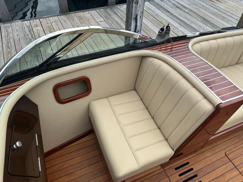 Slide: The Image of Luxurious interior of a 1999 Hacker-Craft Custom Sport boat with beige seating and wooden accents. - 12