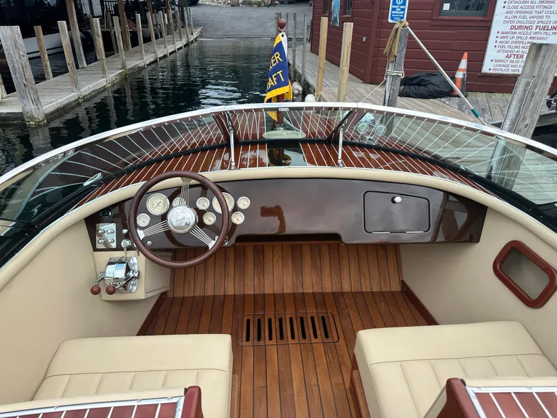 Slide: The Image of 1999 Hacker-Craft Custom Sport boat interior with wooden dashboard and steering wheel. - 15
