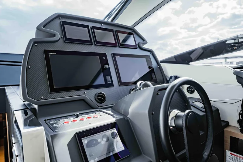 Slide: The Image of Cockpit of 2017 Pershing 70 yacht with advanced navigation displays and steering wheel. - 21