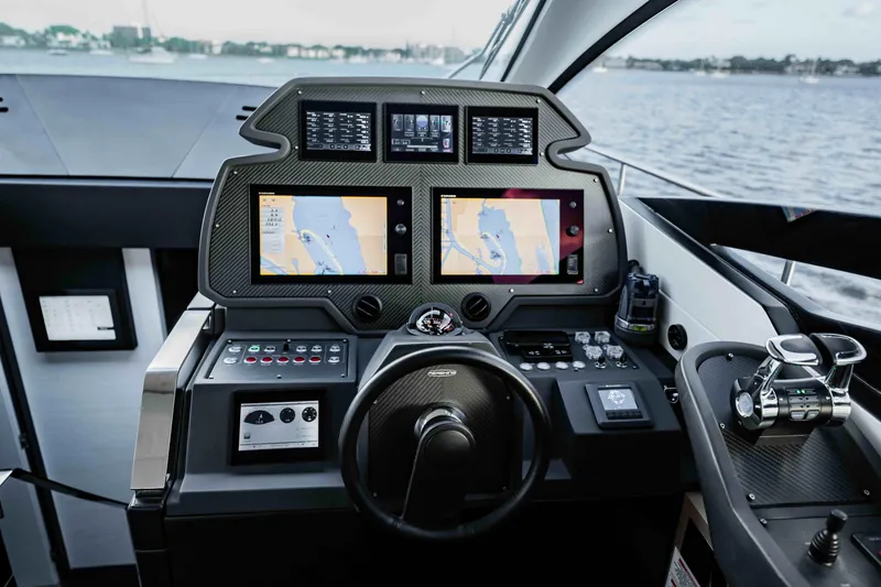 Slide: The Image of Cockpit of 2017 Pershing 70 yacht with navigation screens and controls, overlooking water. - 23