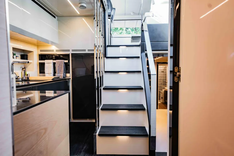 Slide: The Image of Modern interior of 2017 Pershing 70 yacht featuring sleek kitchen and illuminated staircase. - 24